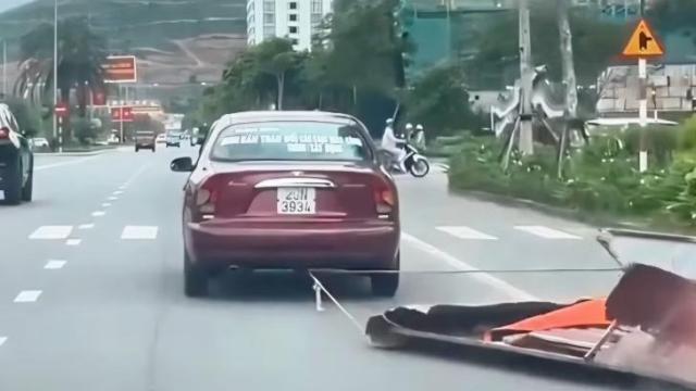 Quảng Ninh - Ô tô buộc dây kéo tấm tôn trên đường