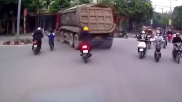 VIDEO- Người đàn ông đi xe máy kéo em nhỏ thoát khỏi điểm mù xe tải